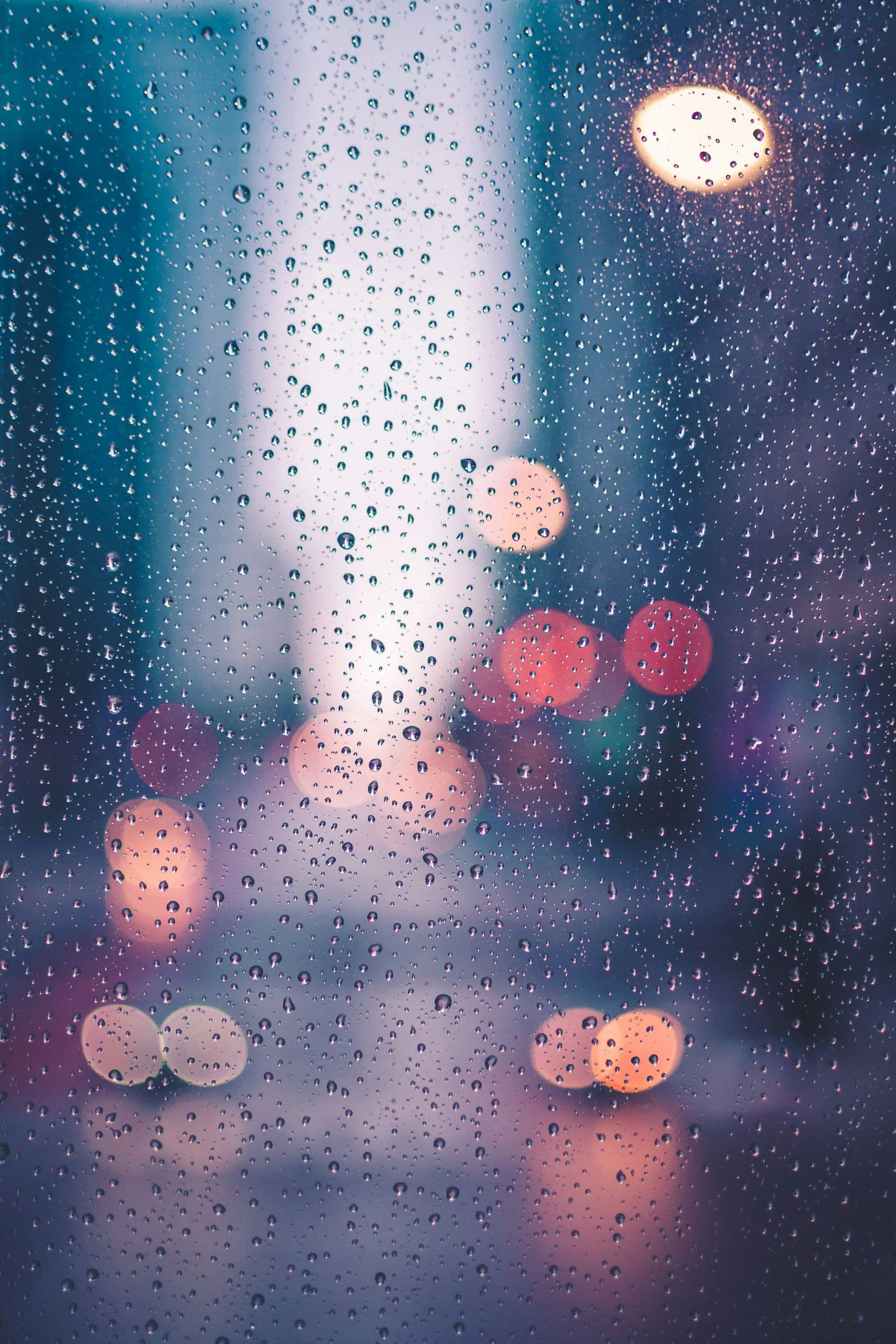 Rainy Window: Rain on the window, city lights blurred